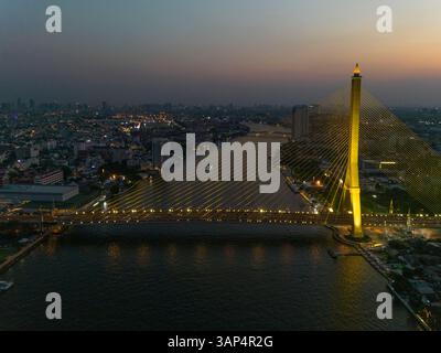 Aus der Vogelperspektive auf die Rama VIII Brücke, eine Kabelbrücke über den Chao Phraya Fluss bei Nacht in Bangkok, Thailand. Stockfoto
