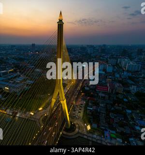 Aus der Vogelperspektive auf die Rama VIII Brücke, eine Kabelbrücke über den Chao Phraya Fluss bei Nacht in Bangkok, Thailand. Stockfoto