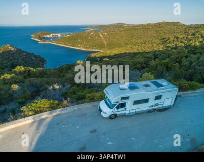 Aus der Vogelperspektive eines Wohnmobils auf der Straße in der Nähe der Stadt Zaklopatica mit einer kleinen Bucht im Hintergrund entlang der Adriaküste, Kroatien. Stockfoto