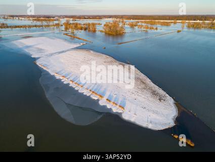 Aus der Vogelperspektive der schneebedeckten Insel, einem höheren Teil der untergetauchten Aue des Flusses IJssel bei Hochwasser im Winter bei Welsum, Overijssel, Niederlande. Stockfoto