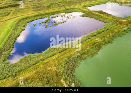 Abstrakte Luftaufnahme des Landschaftsschutzgebietes Volgermeerpolder, errichtet auf einer ehemaligen Mülldeponie, mit blau-grünen Algen in einem o Stockfoto