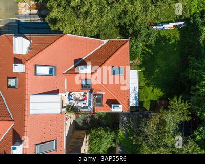 Aus der Vogelperspektive auf der Dachterrasse, wo ein Paar frühstückt. Unterhaltsames Konzept für Menschen, die in der Stadt leben. Stockfoto