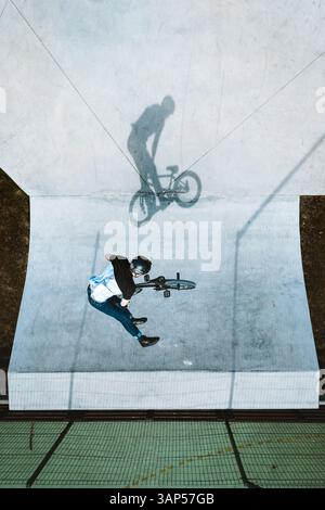 Luftaufnahme eines BMX-Radfahrers, der auf der Rampe im Skatepark Panevezys, Litauen, springt und trickt. Stockfoto