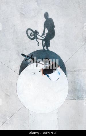 Aus der Vogelperspektive des BMX-Fahrradfahrers, der einen Trick im Skate-Pool in Panevezys, Litauen macht. Stockfoto