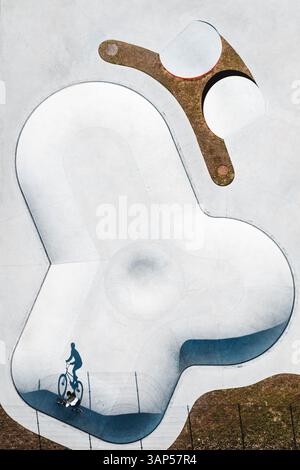 Von oben nach unten auf die Silhouette des BMX-Fahrradfahrers im Betonskate-Pool in der Nähe von Panevezys, Litauen. Stockfoto