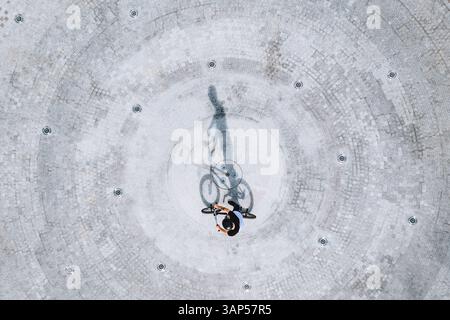 Luftaufnahme des Silhouettenschattens des BMX-Fahrradfahrers auf Betonoberfläche in Panevezys, Litauen. Stockfoto