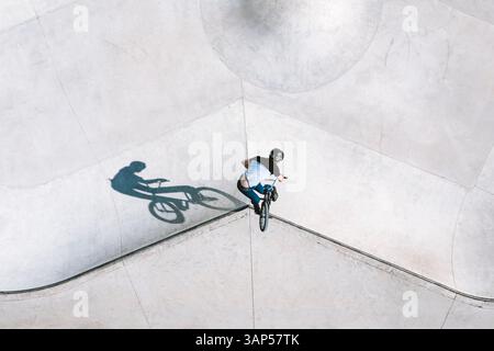 Luftaufnahme eines BMX-Radfahrers, der einen Turn-Down-Trick im örtlichen Skatepark in Panevezys, Litauen, macht. Stockfoto