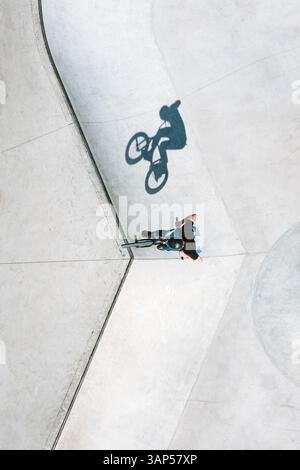 Luftaufnahme eines BMX-Fahrradfahrers, der einen Sprungtrick im örtlichen Skatepark in der Nähe von Panevezys, Litauen, macht. Stockfoto