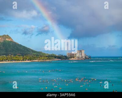 Aus der Vogelperspektive auf den wunderschönen waikiki Strand mit Palmen und einem Regenbogen über dem Meer, honolulu, hawaii, usa. Stockfoto