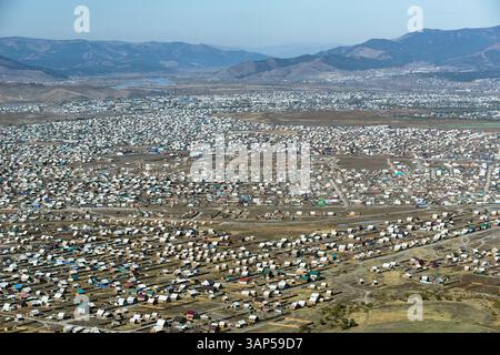 Luftaufnahme der weitläufigen Stadt mit wunderschönen Wohnhäusern und Bergen im Hintergrund, Ulan-Ude, Russland. Stockfoto