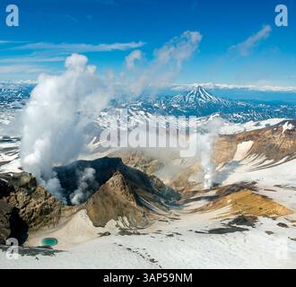 Aus der Vogelperspektive auf den Vulkan gorely mit Rauch und Schnee in einer malerischen Landschaft, Halbinsel Kamtschatka, Russland. Stockfoto