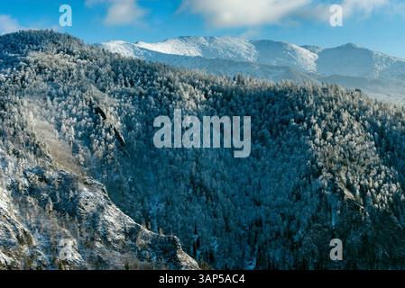 Blick aus der Vogelperspektive auf die atemberaubenden Sayan Berge, bedeckt mit unberührtem Schnee und umgeben von ruhigen Wäldern, Khakassia Republik, Russland. Stockfoto