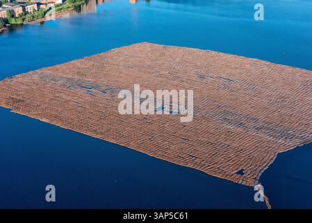 Aus der Vogelperspektive eines ruhigen Holzfloßes, das auf ruhigem Wasser mit wunderschönen Reflexionen schwimmt, Karelien Republik, Russland. Stockfoto