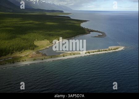 Aus der Vogelperspektive auf den unberührten Baikalsee mit ruhigem blauem Wasser und üppigen Wäldern entlang einer unregelmäßigen Küste, Irkutsk Oblast, Russland. Stockfoto