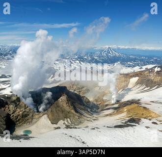 Aus der Vogelperspektive auf den Vulkan Gorely mit Schnee und Dampf in einer dramatischen Landschaft, Halbinsel Kamtschatka, Russland. Stockfoto