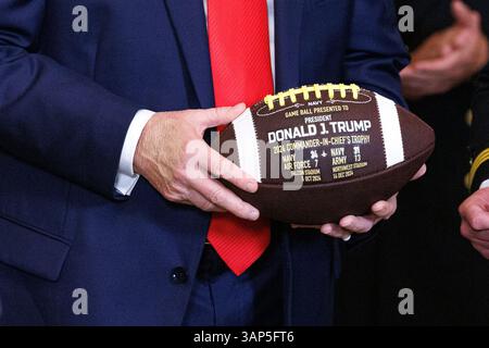 Washington, Usa. April 2025. Präsident Donald Trump hält während einer Veranstaltung, bei der er den Navy Midshipmen der United States Naval Academy die Commander-in-Chief Trophy nach ihrem Meisterschaftssieg im East Room des Weißen Hauses in Washington DC am Dienstag, den 15. April 2025, überreichte. (Foto: Aaron Schwartz/SIPA USA) Credit: SIPA USA/Alamy Live News Stockfoto