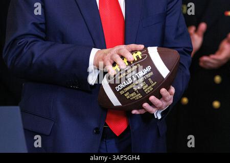 Washington, Usa. April 2025. Präsident Donald Trump hält während einer Veranstaltung, bei der er den Navy Midshipmen der United States Naval Academy die Commander-in-Chief Trophy nach ihrem Meisterschaftssieg im East Room des Weißen Hauses in Washington DC am Dienstag, den 15. April 2025, überreichte. (Foto: Aaron Schwartz/SIPA USA) Credit: SIPA USA/Alamy Live News Stockfoto
