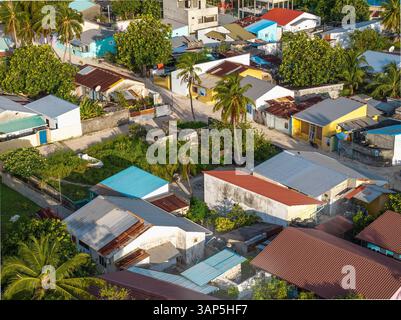 Blick aus der Vogelperspektive auf farbenfrohe Häuser und Palmen im tropischen Paradies, Vashafaru, Malediven. Stockfoto