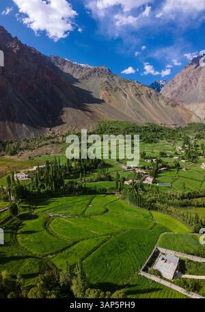 Aus der Vogelperspektive auf das ruhige Phander Valley mit üppigem Grün, malerischen Feldern und abgelegenen Häusern, umgeben von majestätischen Bergen, Phander, Pakistan. Stockfoto