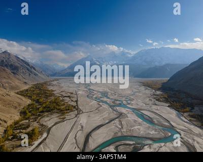 Aus der Vogelperspektive auf schneebedeckte Berge und den sich schlängelnden Fluss in Machulo La, Central Karakoram National Park, Pakistan. Stockfoto