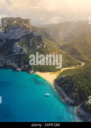 Aus der Vogelperspektive eines kleinen Bootes, das in der Nähe eines paradiesischen Strandes schwimmt, Blick auf das türkisfarbene Wasser des Mittelmeers in Cala Gonome, Sardinien, Italien. Stockfoto