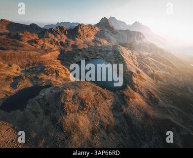 Aus der Vogelperspektive auf die ruhige Alpenlandschaft mit majestätischen Bergen und einem ruhigen See bei Sonnenuntergang, Sils, Kanton Graubunden, Schweiz. Stockfoto