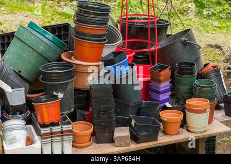 Gärtner-Topftisch mit verschiedenen Größen leere Plastikbehälter auf Tisch im Garten im Sommer. Stockfoto