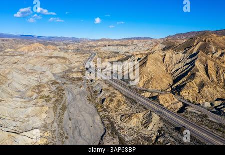 Aus der Vogelperspektive auf die Wüste Tabernas mit zerklüfteten Bergen und einer gewundenen Straße, Gador, Provincia de Almeria, Spanien. Stockfoto