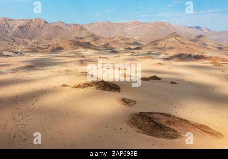 Aus der Vogelperspektive auf das trockene Bett des Ugab-Flusses durchzieht trockene Wüstenebenen und liegt am Brandberg, Namibias höchstem Berg, aus der Vogelperspektive, Drohnensho Stockfoto