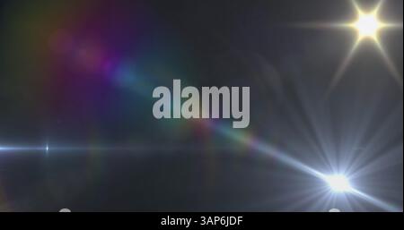 Bild von Spotlights mit Streulicht und Lichtstrahlen, die sich über dunklem Hintergrund bewegen Stockfoto
