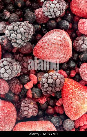 Gefrorene Obstsortiment mit Erdbeeren, Brombeeren, schwarzer Johannisbeere und roter aktueller Hintergrund. Tiefkühlkost-Konzept. Stockfoto