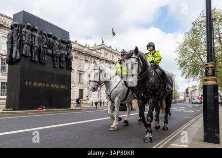 Die Metropolitan Police führte Polizeibeamte, die an der Statue der Frauen des Zweiten Weltkriegs in Whitehall, Westminster, London, vorbeifuhren Stockfoto