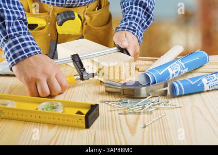 Die Hände des Zimmermanns machen das Befestigen von Holzdielen Stockfoto
