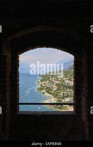 Blick auf den Gardasee in der Nähe von Malcesine durch ein Fenster auf das Schloss Scaligero, Castello Scaligero Stockfoto