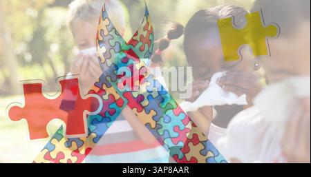 Bild eines bunten Puzzletücks über Kindern, die sich die Nase blasen Stockfoto
