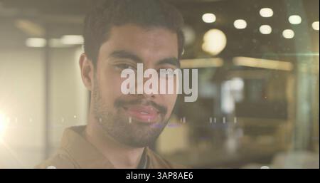 Bild von Lichtflecken über birassischem Geschäftsmann lächelnd Stockfoto