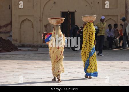 Fort Amber, Amber, in der Nähe von Jaipur, Rajasthan, Nordindien, Indien, Asien, zwei Frauen in traditionellen Saris mit Körben auf dem Kopf in einer offenen Courtya Stockfoto