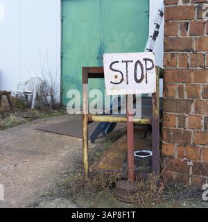 Unterschreiben Sie mit der Aufschrift Stop auf einer verlassenen Firmenseite Stockfoto