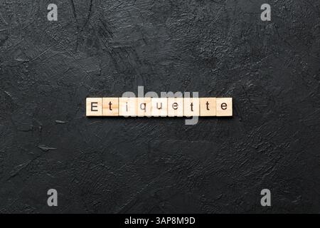 ETIKETTE Wort auf Holzblock geschrieben. ETIKETTE Text auf Zementtisch für Ihr Design, Konzept. Stockfoto