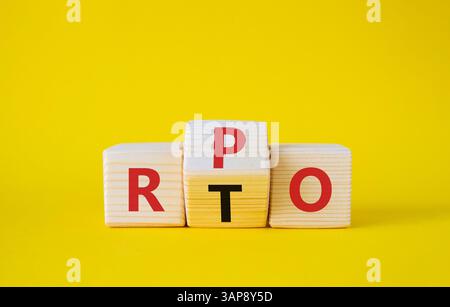 RPO vs. RTO-Symbol. Holzwürfel mit den Wörtern RTO und RPO. Schöner gelber Hintergrund. Geschäftskonzept. Kopierbereich Stockfoto