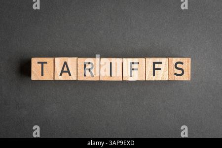 Tarife, Wort auf quadratischen Holzblöcken. Gegen dunkelgraue Oberfläche. Stockfoto