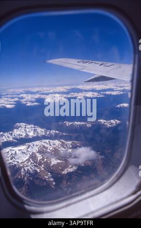 Argentinien, Blick auf einen Flugzeugflügel, der über die schneebedeckten Anden fliegt. Stockfoto