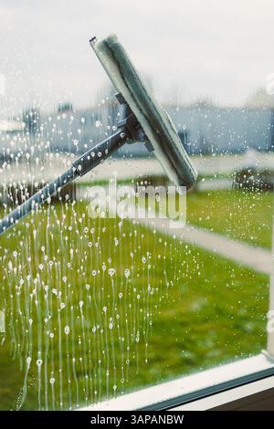 Glasreinigung mit Spezialchemikalien. Reinigungsservice in einem Hochhaus. Stockfoto