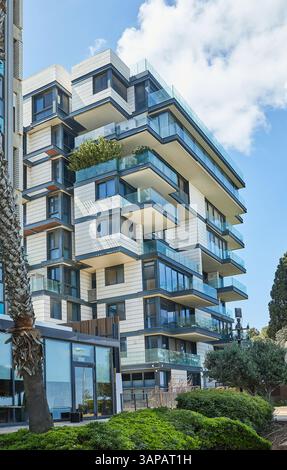 Modernes Wohngebäude in Haifa, Israel, mit Glasbalkonen und geometrischer Architektur, das zeitgenössisches urbanes Leben an der Küste widerspiegelt. Stockfoto