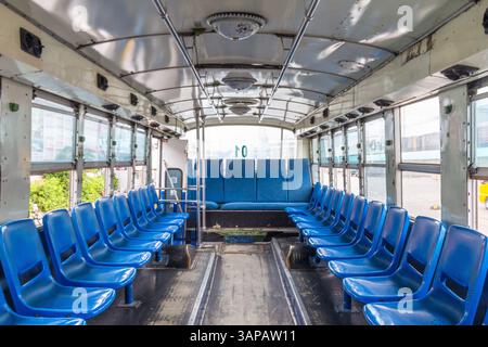 Innenraum eines kleinen lokalen Busses mit blauen Sitzen, der Fährpassagiere von Terminal zu Schiff an einem Pier in Cebu, Philippinen, transportiert Stockfoto