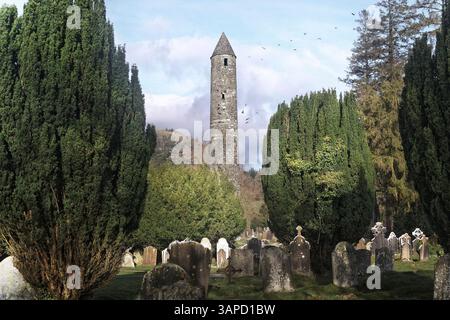 Der Round Tower und der alte Friedhof in Glendalough, eine Klosterstätte aus dem 6. Jahrhundert, die von St. Kevin in in Wicklow, Irland, gegründet wurde. Stockfoto