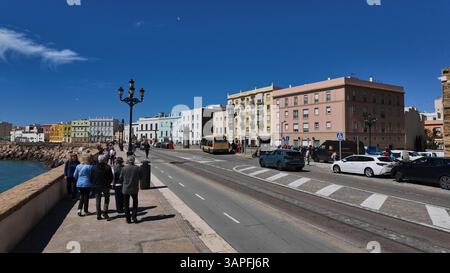 Gruppe von Touristen, die an einem sonnigen Tag entlang der Küste von Cadiz, Andalusien, Spanien, wandern - CADIZ, SPANIEN - 26. MÄRZ 2025 Stockfoto