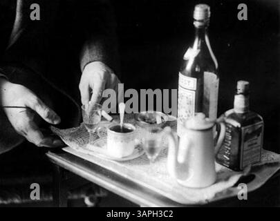 Dieses Bild fängt die Hände von John Jacob Niles ein, der Tee serviert und die traditionelle Akte aus der Sammlung der University of Oregon Libraries aus Berea hervorhebt. Stockfoto