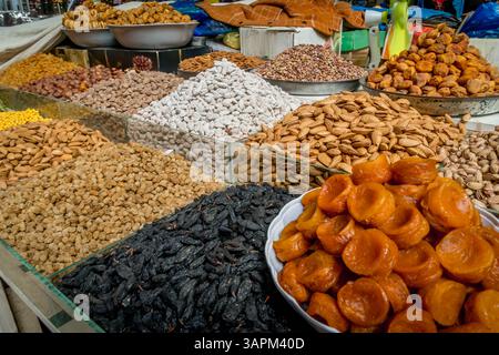 Eine reichhaltige Auswahl an getrockneten Bio-Maulbeeren, goldenen Rosinen, sonnengetrockneten Aprikosen und geschälten Pistazien auf dem geschäftigen Markt von Duschanbe. Stockfoto