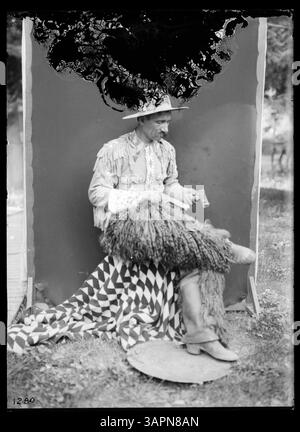 Dieses Lee Moorhouse Foto zeigt Munshang, einen Cowboy in voller Kostümierung, der ein Gewehr hält. Das Bild spiegelt Cowboykleidung und Lebensstil im amerikanischen Westen während des frühen 20. Jahrhunderts wider. Stockfoto